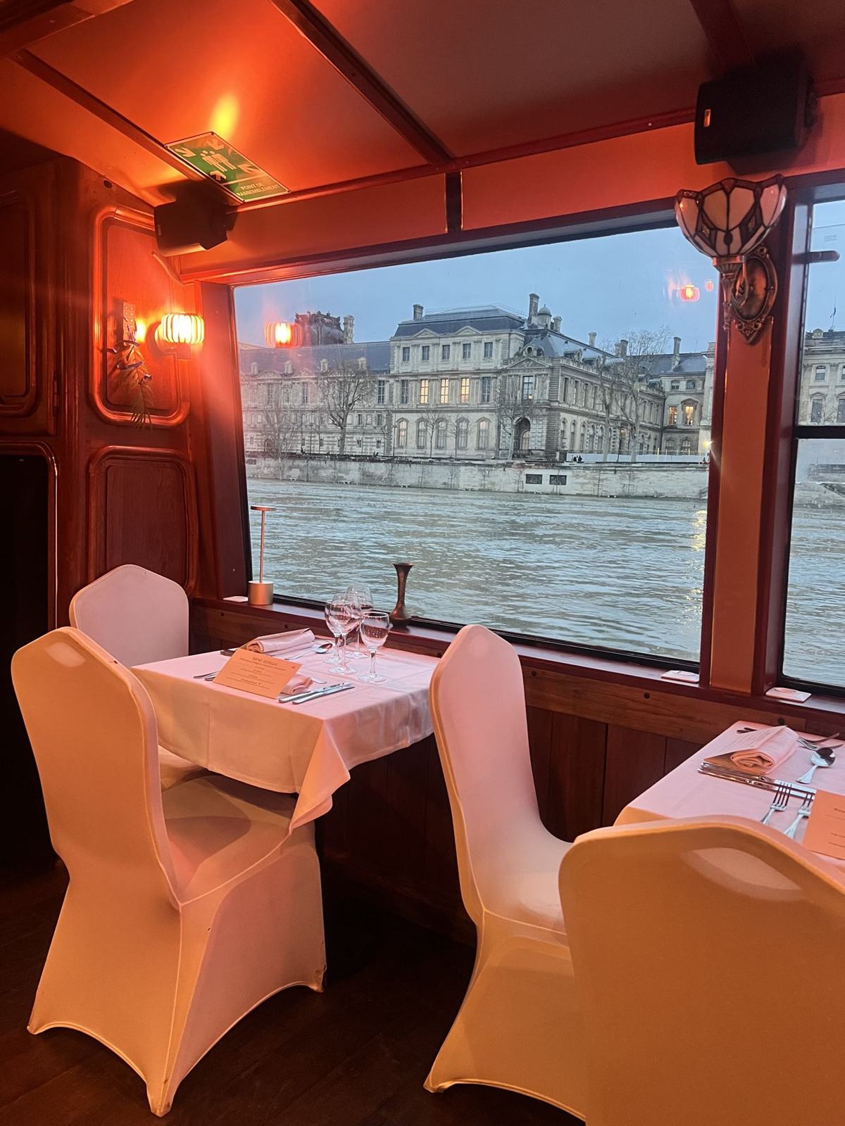 A table by a bay window, facing the Louvre