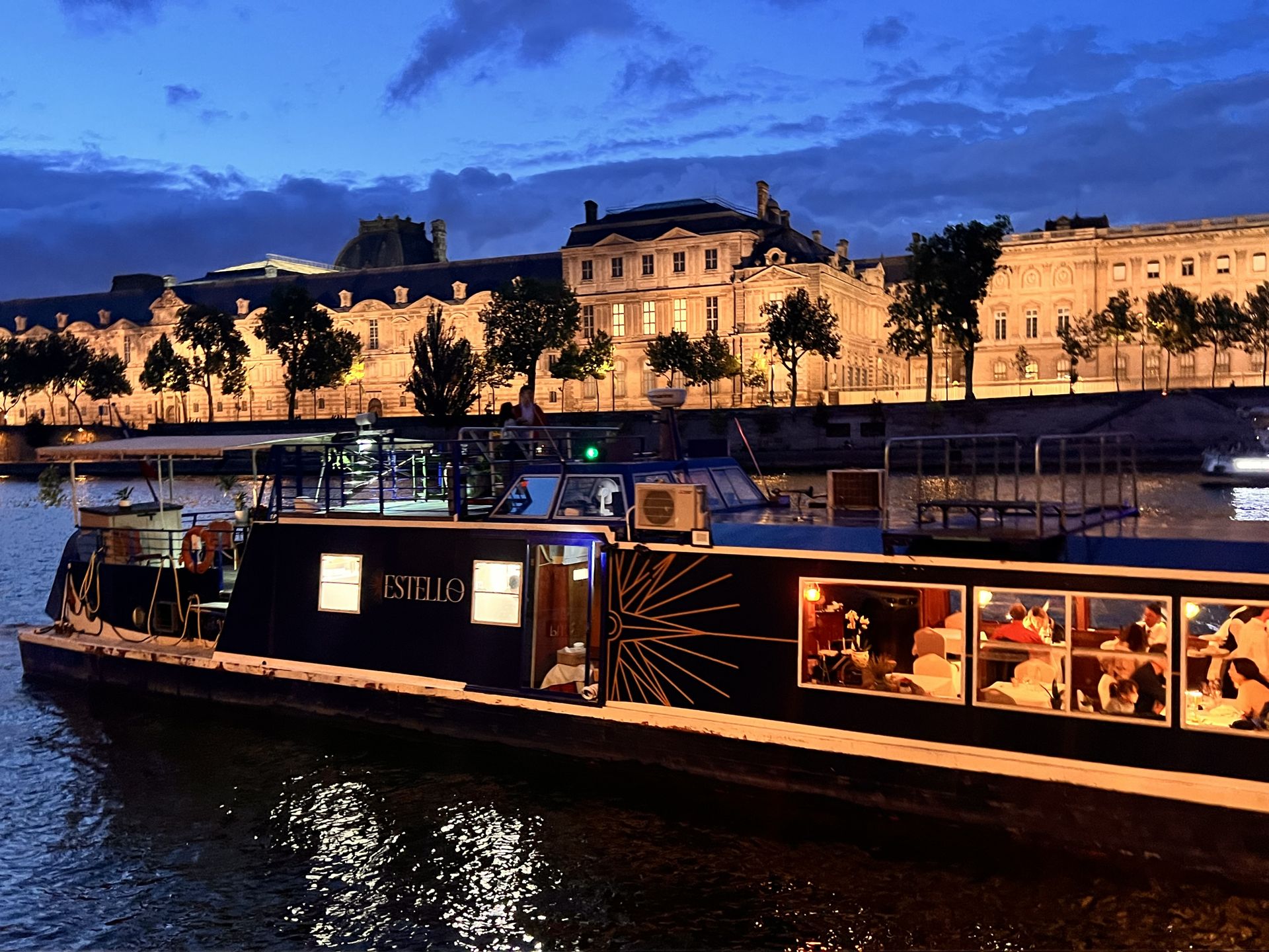 L’Estello illuminé sur la Seine, de nuit, devant le Louvre